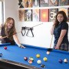 two students playing billiards