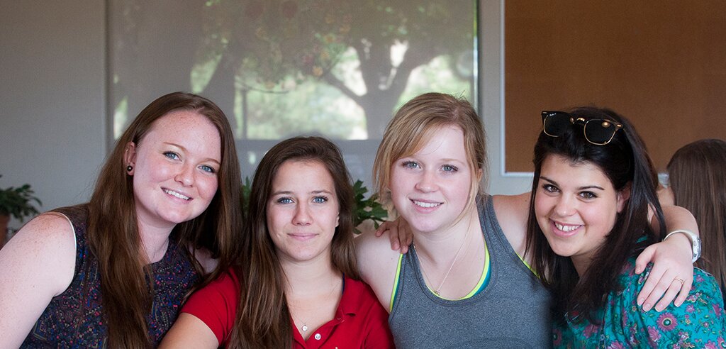 four girls with arms around each other